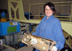 One of Frutti Felici's workers is showing a box befor it goaes under the palletizing machine.