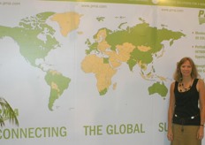 Nancy Teucker of the PMA stands next to a global map. All the green area are countries with members of the PMA.