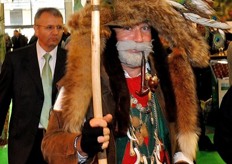 "A man dressed in the traditional costume of the "Saltner" figure dating from the nineteenth century. The Saltner was a guardian of fields and vineyards, which was used for the protection of crops from damage caused by animals or stolen by thieves and hoodlums. His costume consists of shirt, trousers and leather belt embroidered with doublet and short sleeves in black leather, is completed by a large hat adorned with feathers and fox tails. He wears around his neck a chain with boar's teeth and silver medals. He is equipped with horns and halberds to scare away animals, a whip and even a gun as a deterrent to intruders. Since he carries out his service especially at night, he brings with him amulets to protect him from evil spirits."